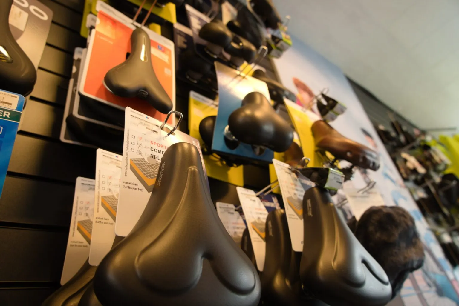 Wand met fietszadels in de winkel