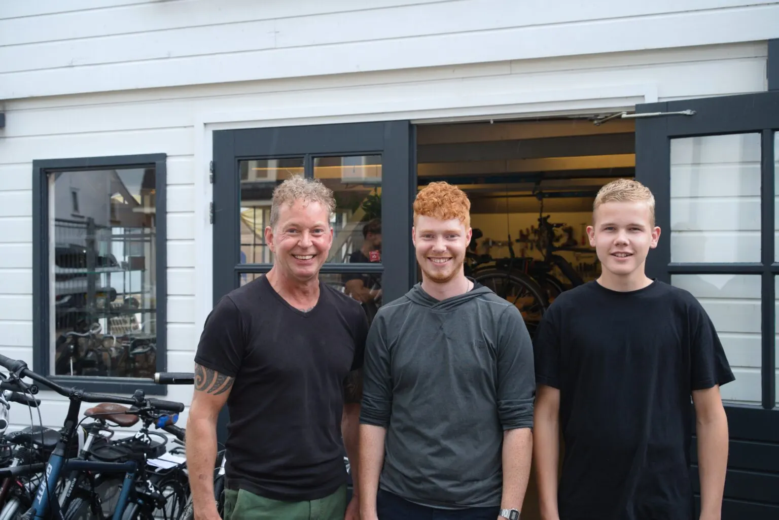 Henry IJzerman met zijn team voor de winkel